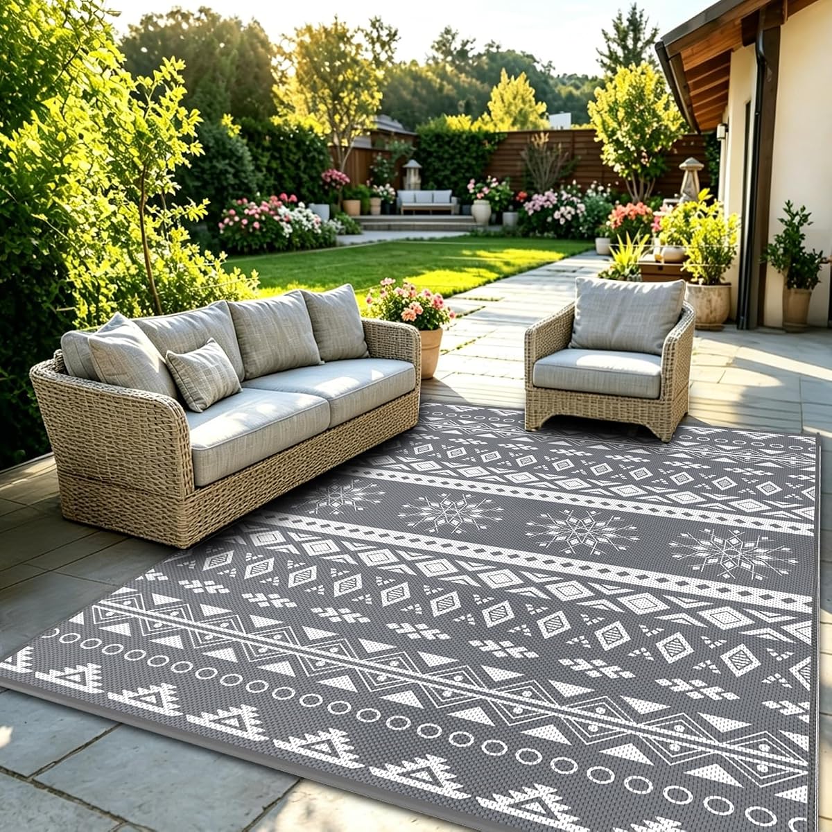 Tapis d’extérieur gris réversible posé sur une terrasse en bois après la pluie