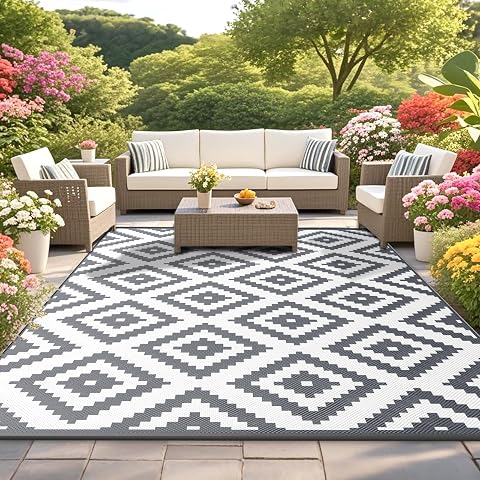 Tapis d’extérieur réversible gris et blanc déployé sur une terrasse claire avec quatre piquets