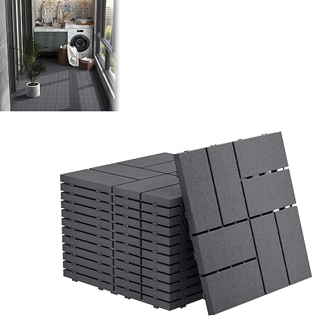 Dalles clipsables anthracite à aspect bois, une posée et les autres empilées sur une terrasse