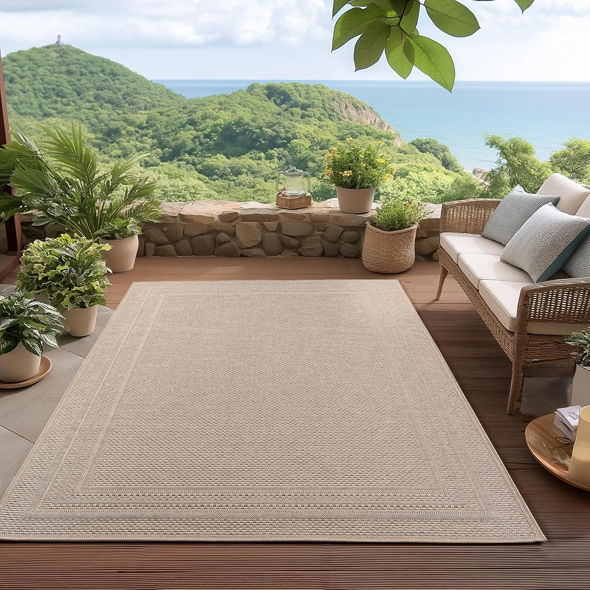 Tapis d’extérieur beige à tissage plat et bordure posé sur une terrasse en bois après la pluie