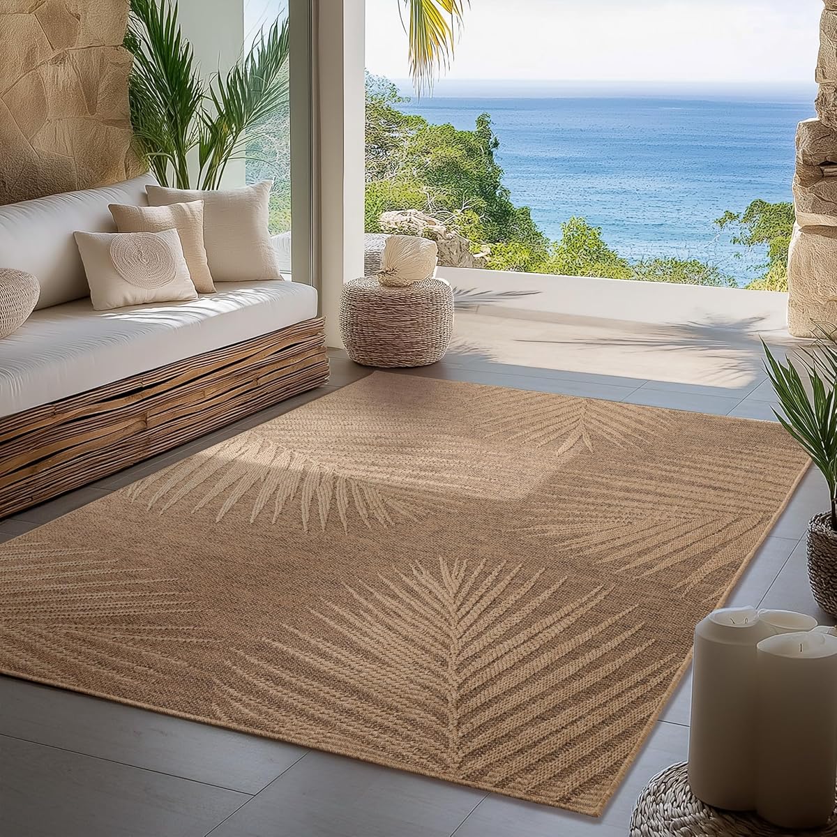 Tapis d’extérieur beige à motif de palmiers et aspect jute naturel posé sur une terrasse en bois