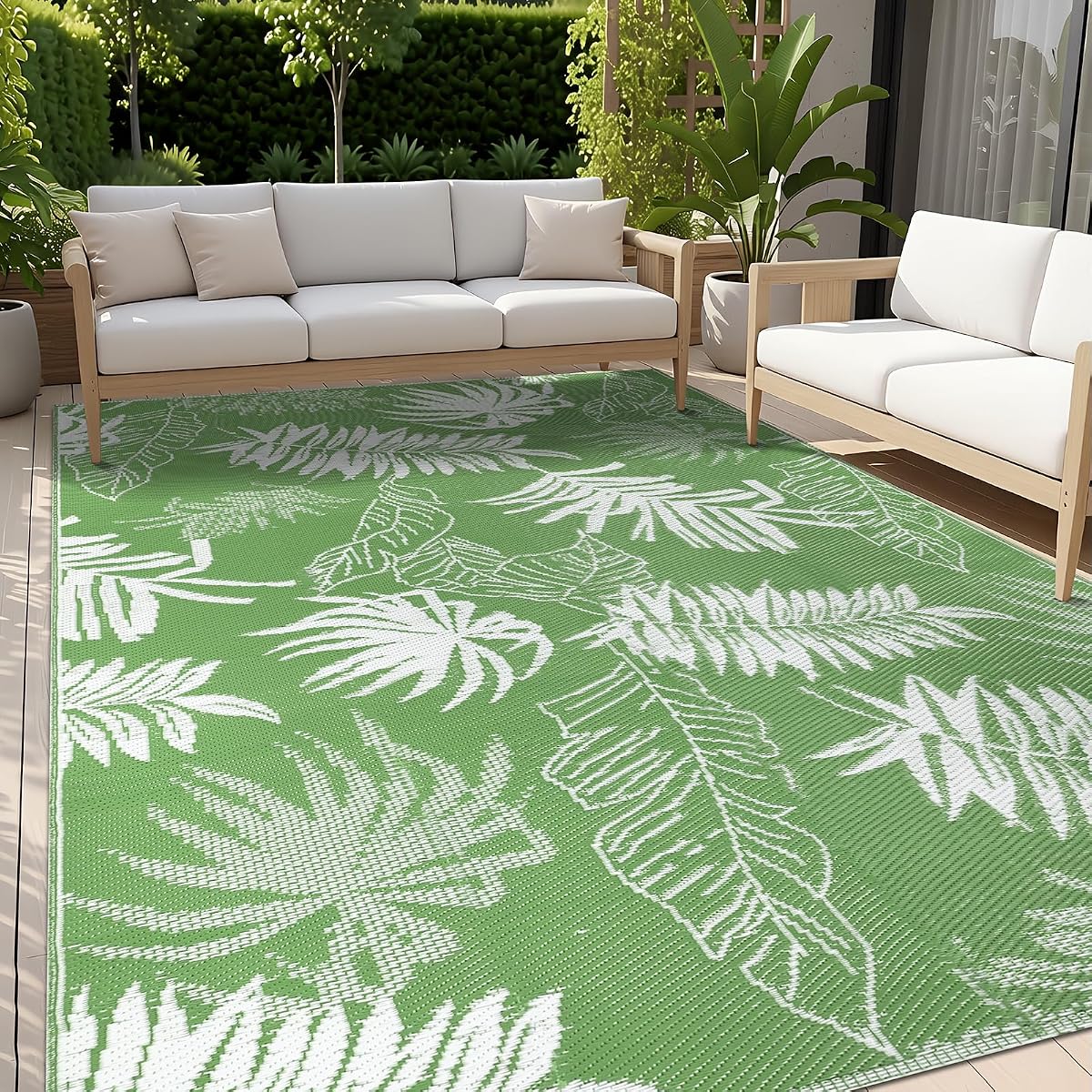 Tapis extérieur vert à motif de feuilles de palmier déployé sur une terrasse en bois après la pluie