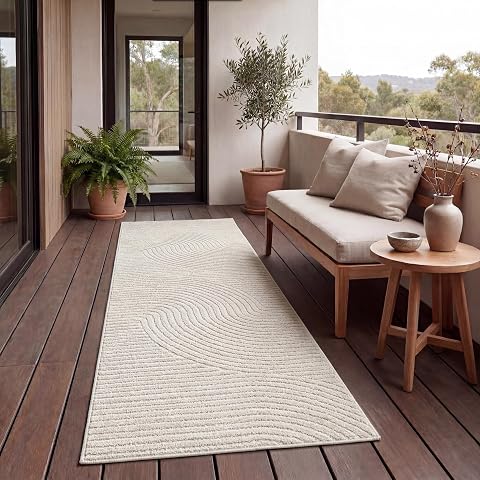 Tapis rectangulaire uni crème à poils ras posé sur une terrasse en bois après la pluie