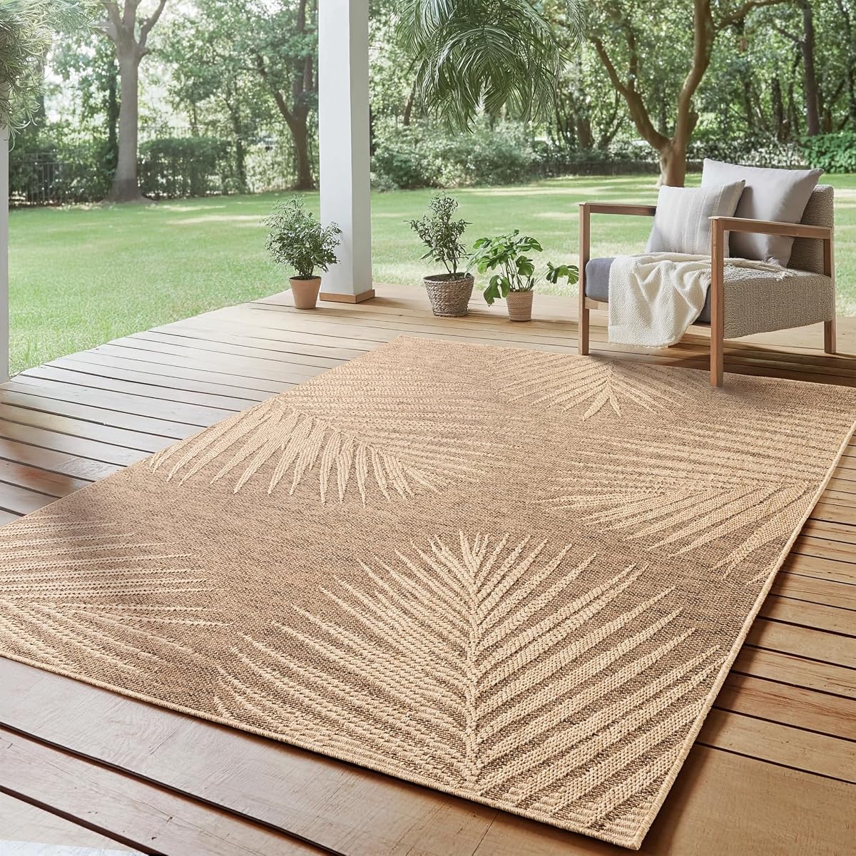 Tapis d’extérieur beige effet jute à motif palmiers posé sur une terrasse en pierre claire