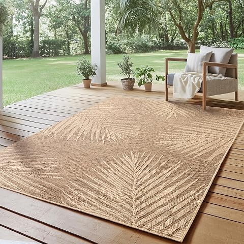 Tapis d’extérieur beige effet jute à motif palmiers posé sur une terrasse en pierre claire