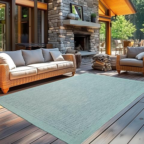 Tapis rectangulaire bleu uni à tissage plat posé sur une terrasse en pierre claire