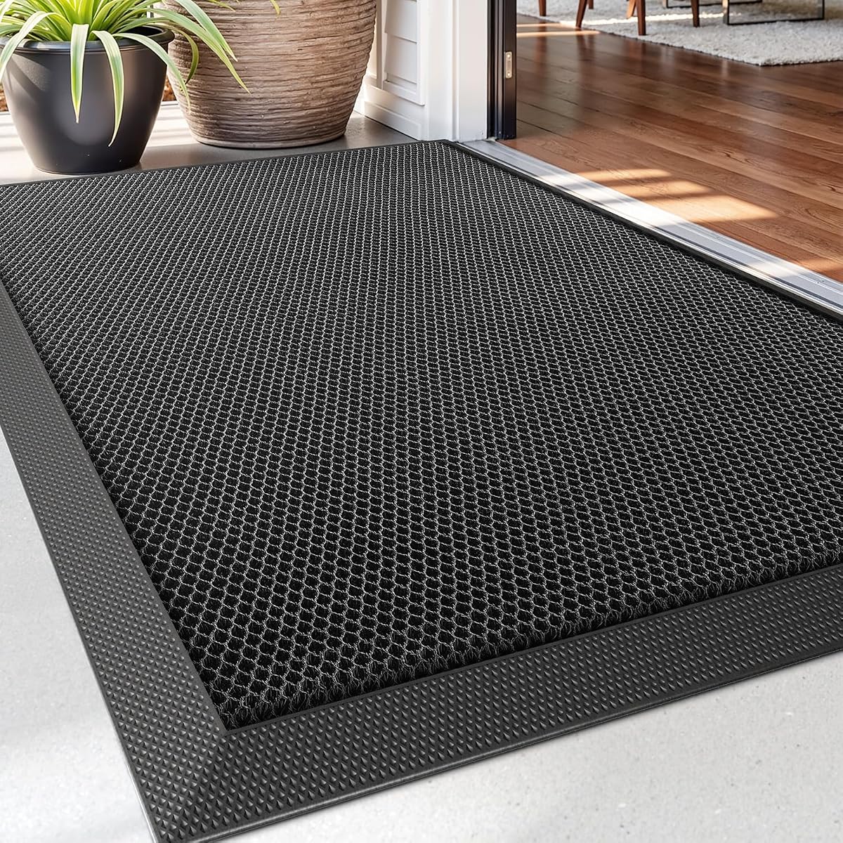 Paillasson noir rectangulaire à surface alvéolée posé devant une entrée extérieure abritée