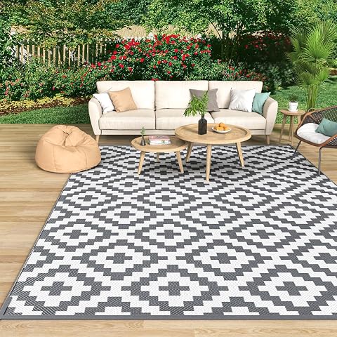 Tapis d’extérieur gris et blanc à motif géométrique posé sur une terrasse après la pluie
