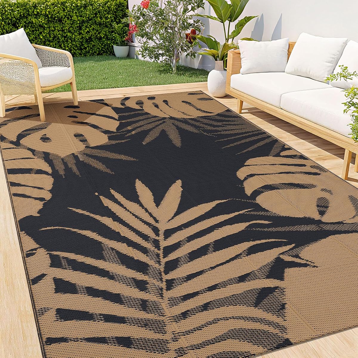 Tapis d’extérieur réversible en polypropylène, motif géométrique marron et noir sur une terrasse