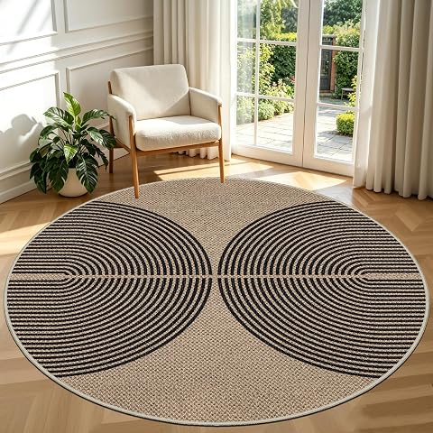Tapis rond noir à l’aspect jute, motif en double arc, posé sur une terrasse en bois après la pluie